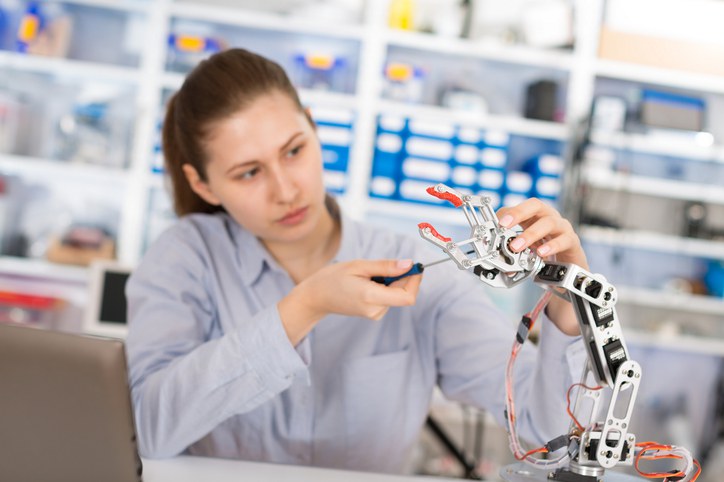 Frau arbeitet an Roboterarm